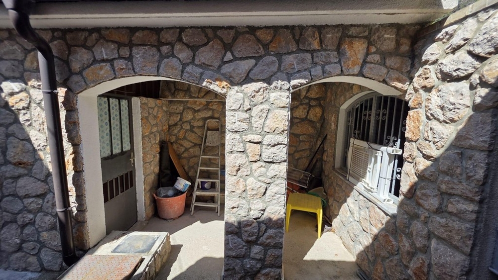 Ingresso coperto con facciata in pietra naturale e archi a tutto sesto