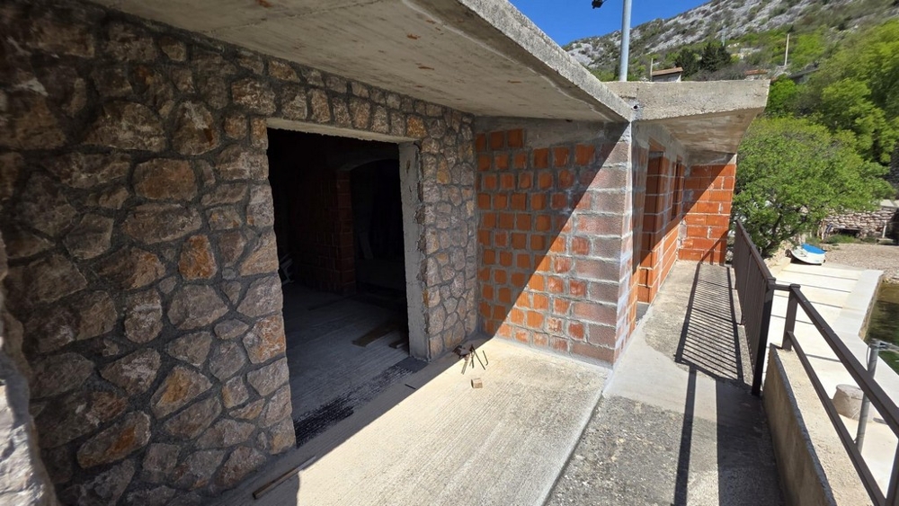 Area esterna con muro in pietra naturale e terrazza coperta
