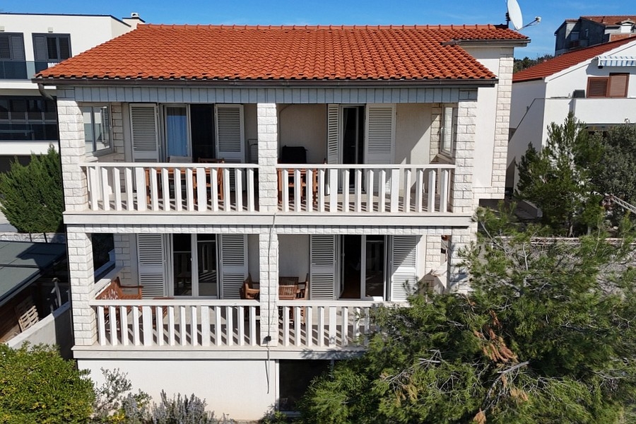 Vista della casa con terrazze e tetto in tegole rosse vicino alla costa