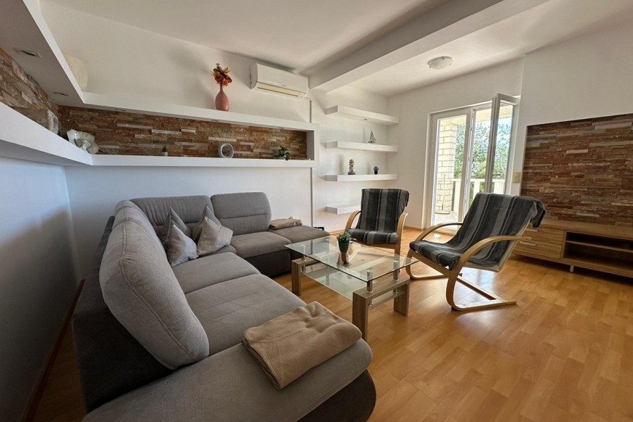 Soggiorno con divano, poltrona e parete dal design moderno
