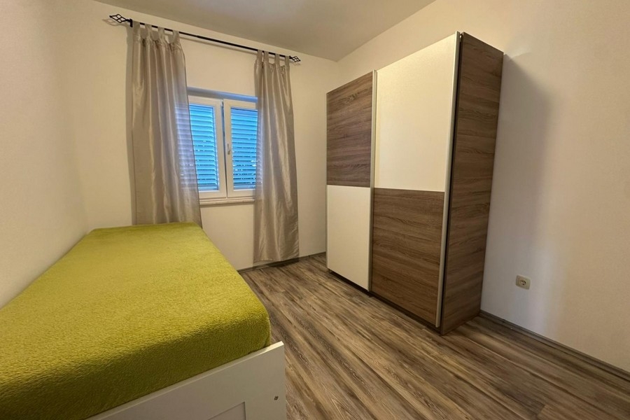 Camera da letto con letto singolo e armadio in arredamento chiaro