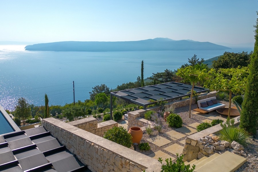 Giardino con muri in pietra naturale e vista mare