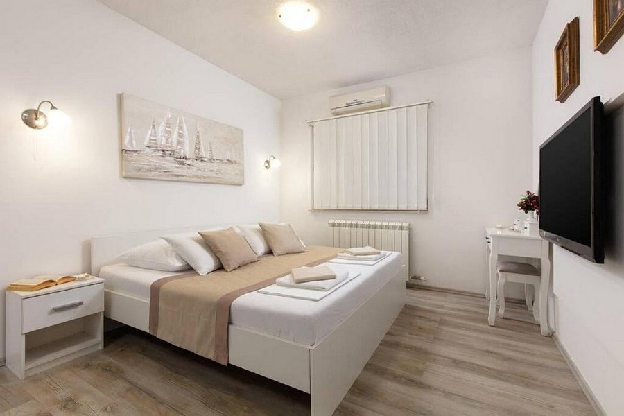 Camera da letto con arredamento moderno, climatizzatore e TV