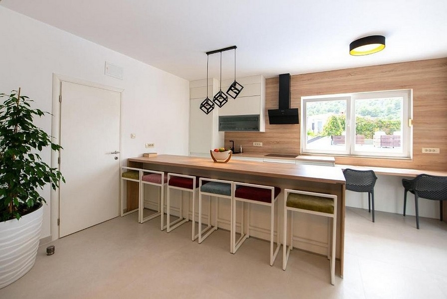 Cucina a vista con isola e sedute in stile moderno