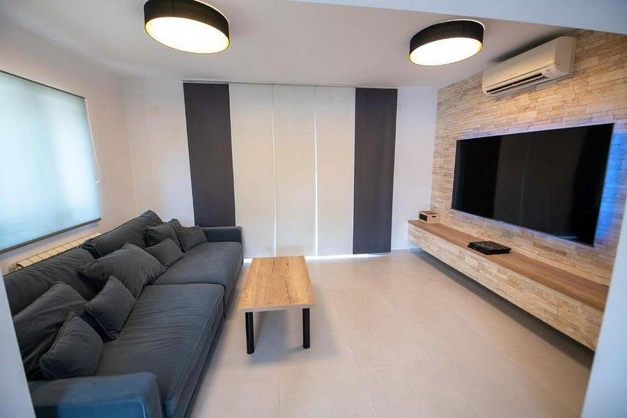 Soggiorno con ampia parete TV e moderna decorazione delle pareti