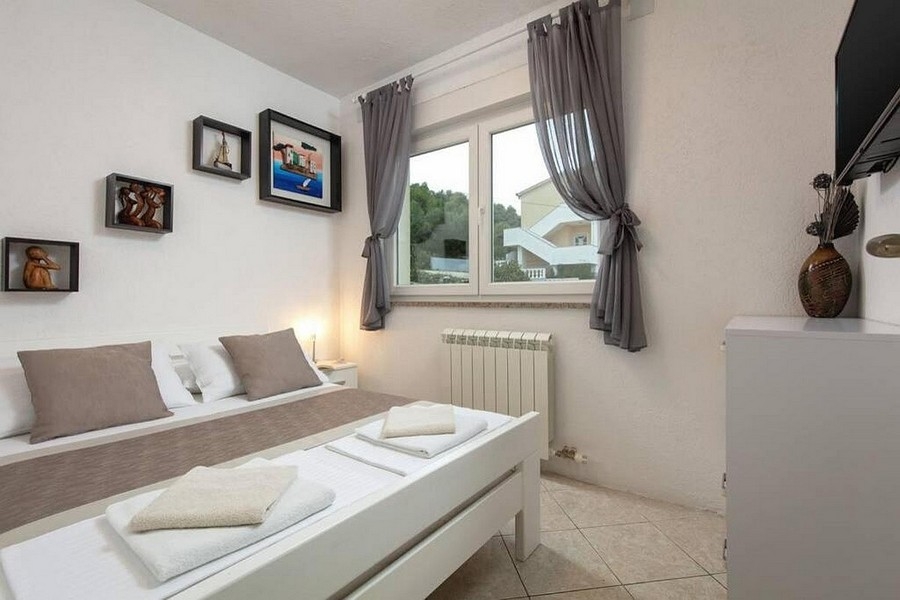 Camera da letto con letto matrimoniale e finestra con vista sul verde