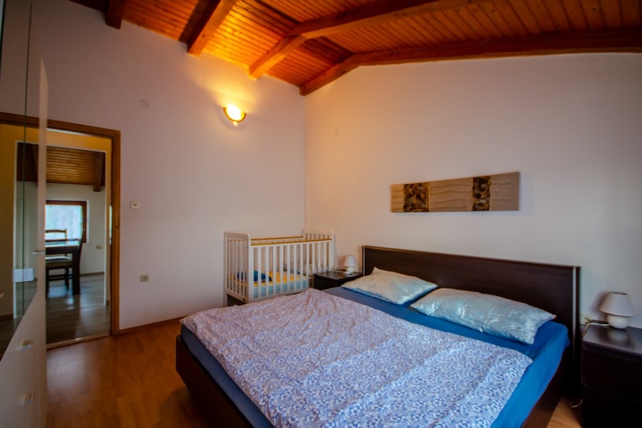 Camera da letto con letto matrimoniale e soffitto con travi in legno