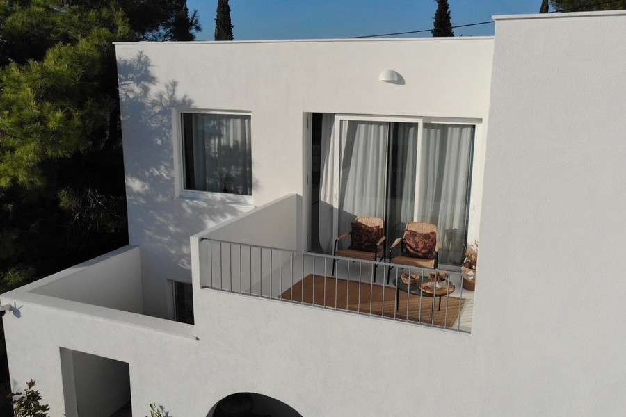 Balcone con due poltrone e tende alla porta della terrazza