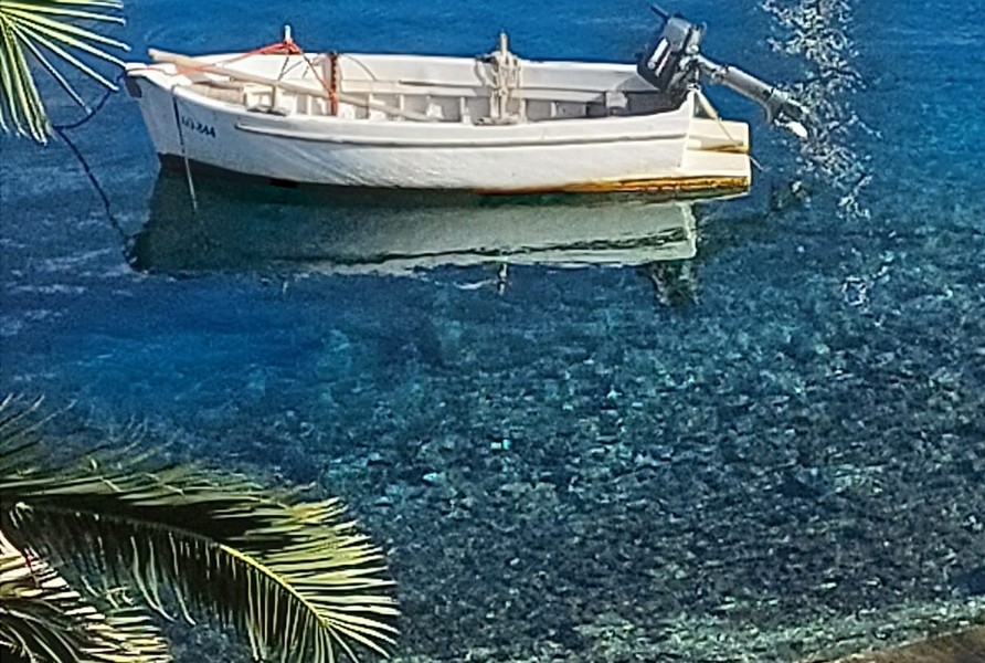 Acqua limpida con barca vicino alla costa