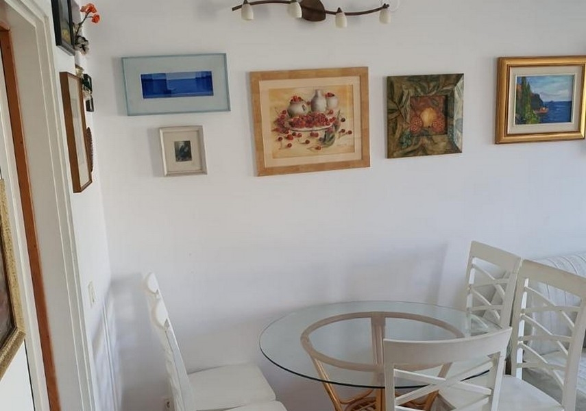 Zona pranzo con tavolo rotondo e decorazione alle pareti