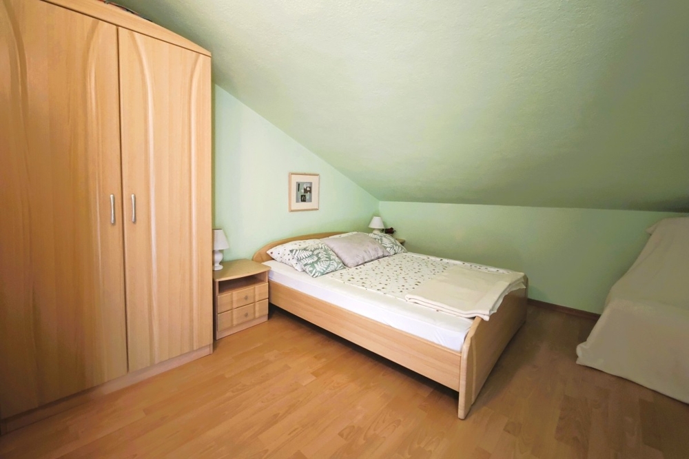 Stanza nel sottotetto con soffitto spiovente e letto singolo