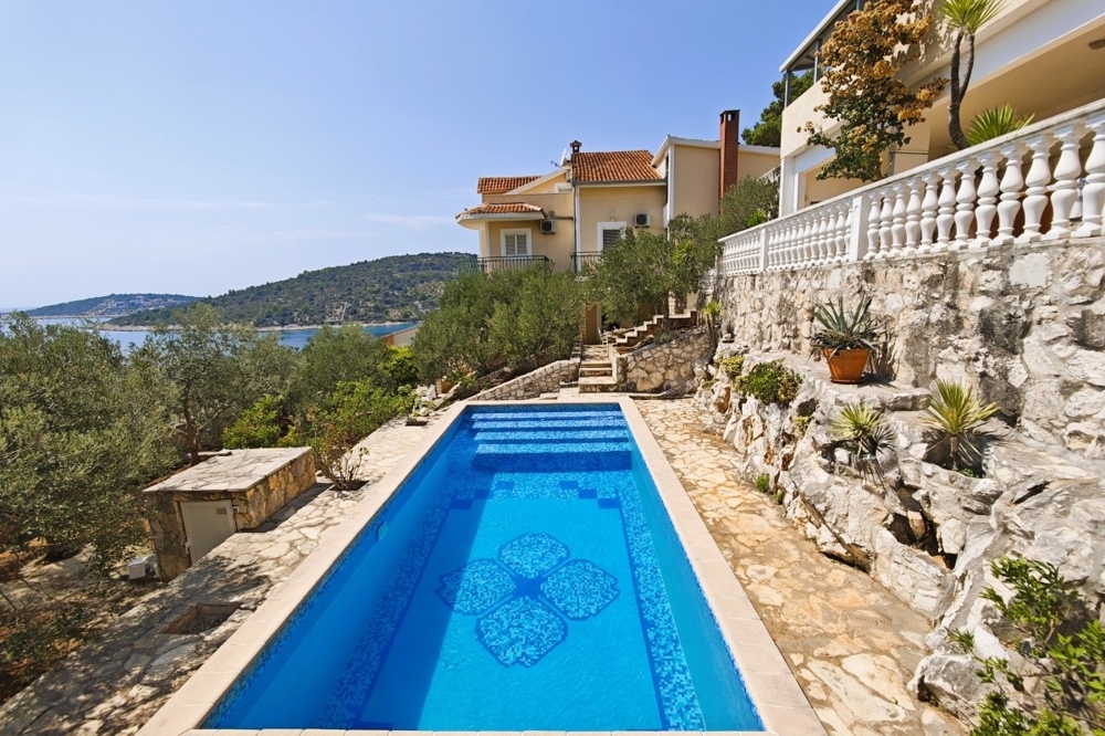 Piscina con vista mare e terrazza in pietra naturale