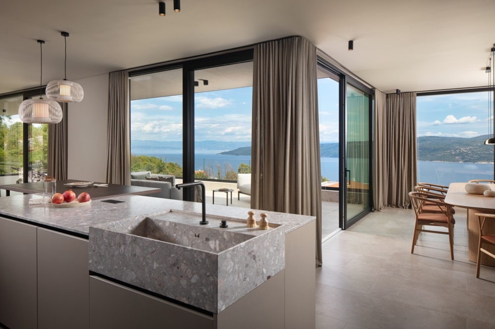 Zona giorno aperta con cucina e accesso diretto alla terrazza
