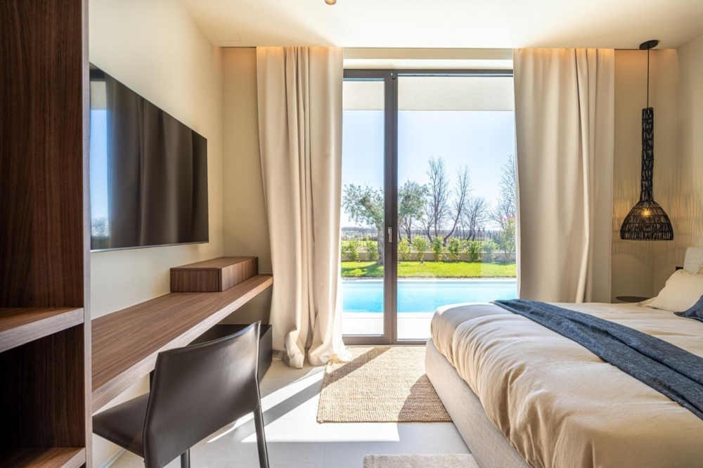 Camera da letto con vista diretta sul giardino e sulla piscina