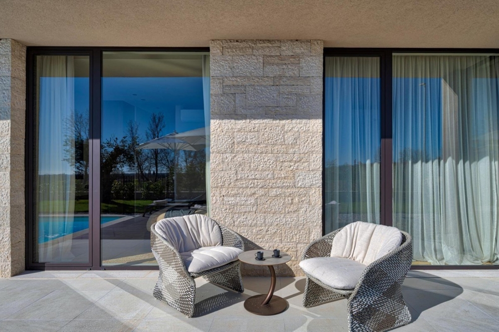 Terrazza coperta con zona salotto e porte scorrevoli in vetro