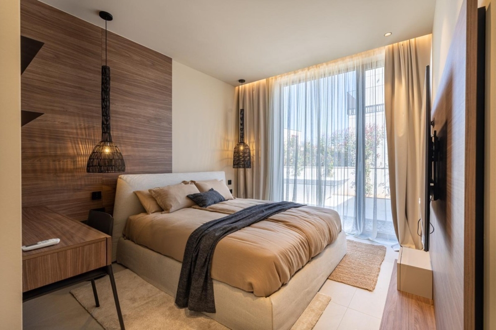 Camera da letto con grandi superfici vetrate e tende