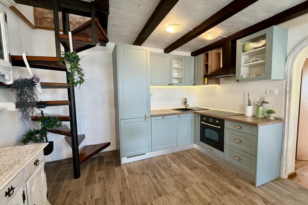 Cucina a vista con mobili su misura e scala in legno