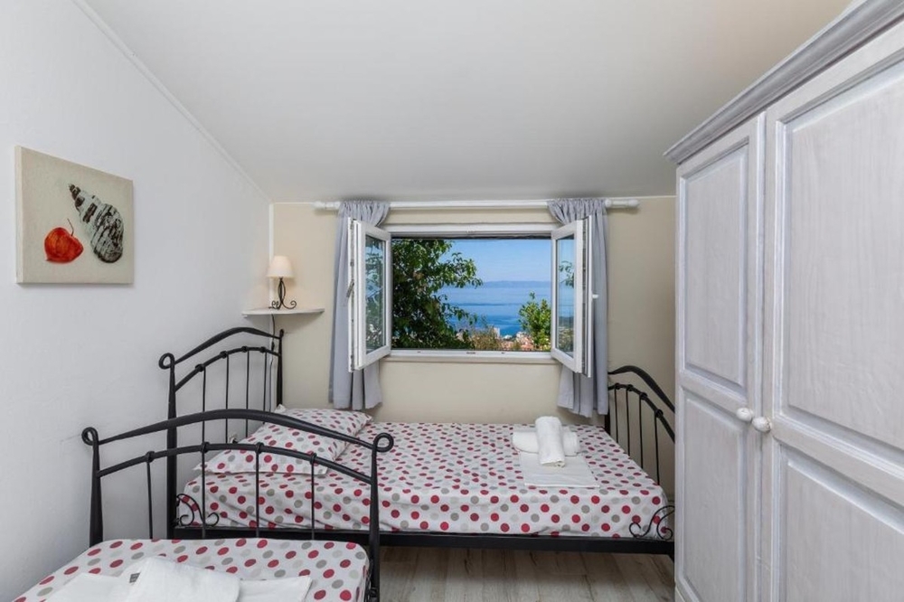 Camera da letto con letti singoli e vista mare dalla finestra