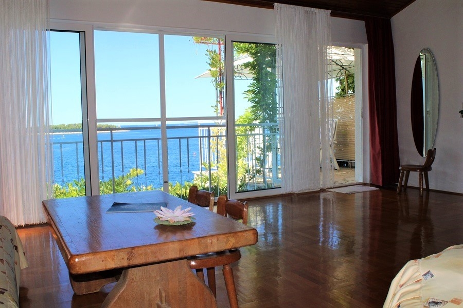 Zona giorno con grandi vetrate e accesso alla terrazza con vista mare