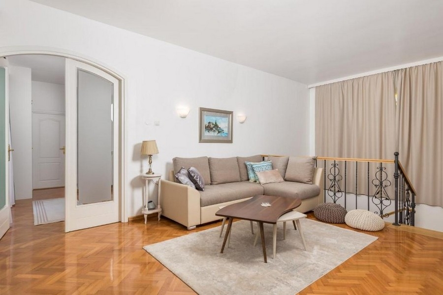 Zona giorno al piano superiore con divano e parquet