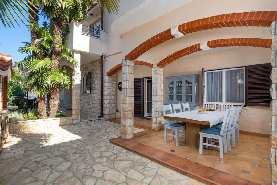 Terrazza coperta con salotto e facciata in pietra naturale