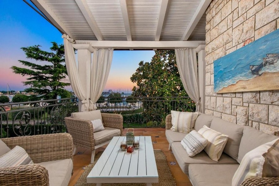 Balcone con mobili lounge e vista mare al tramonto