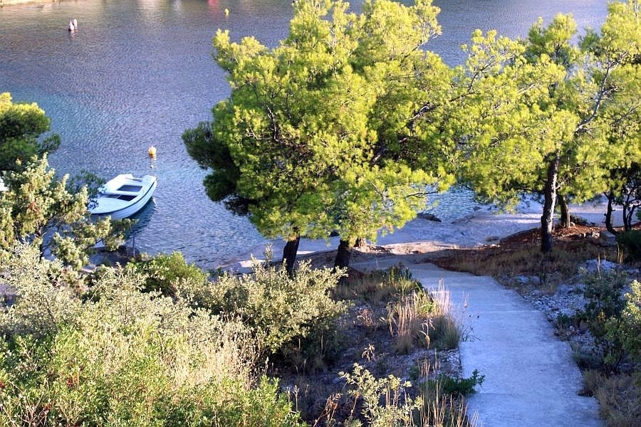 Sentiero verso la spiaggia con barca in una baia tranquilla