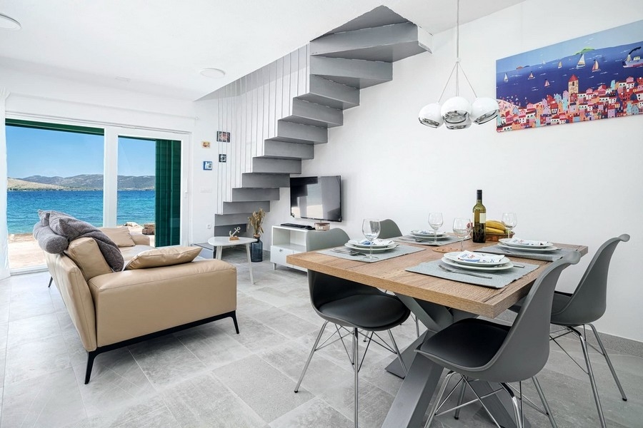 Zona giorno moderna con vista mare e accesso alla terrazza
