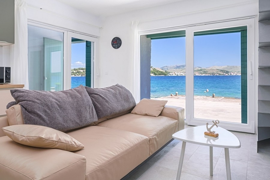 Soggiorno con divano e vista diretta sul mare