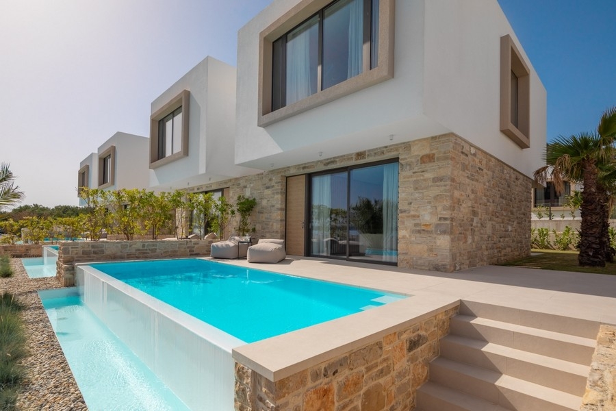 Piscina con rivestimento in pietra naturale davanti alla villa moderna