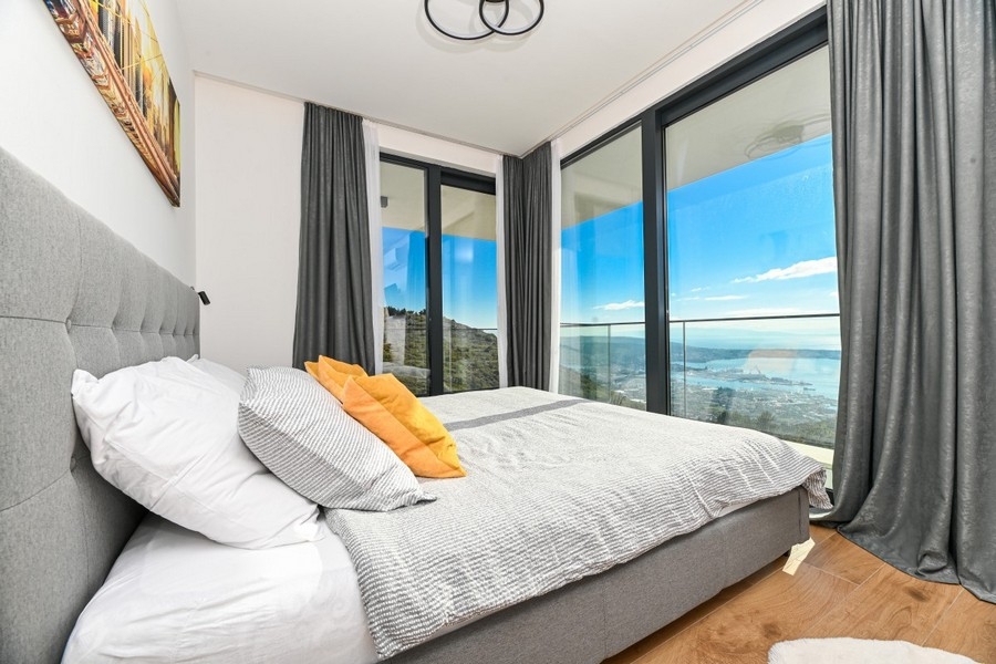 Camera da letto con finestre panoramiche e vista mare