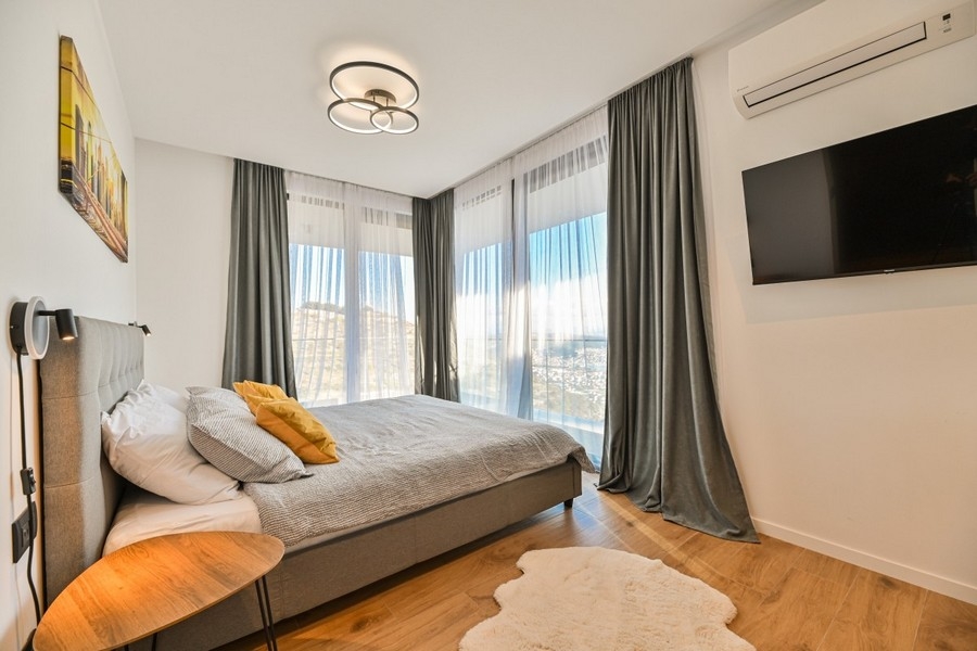 Camera da letto con finestre a tutta altezza e panorama