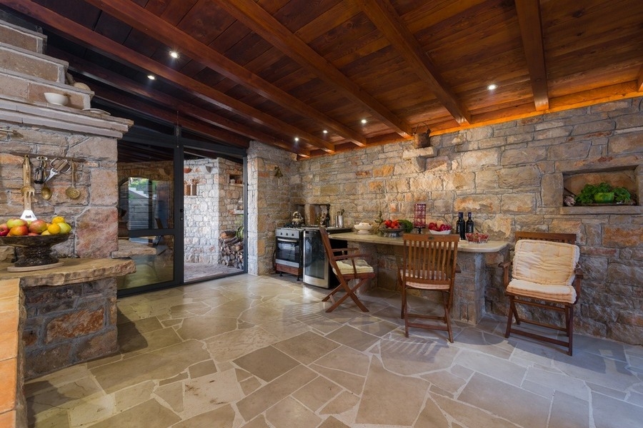 Cucina rustica con pareti in pietra naturale e soffitto in legno
