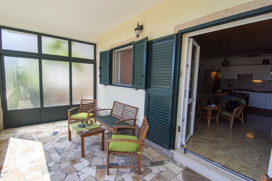 Terrazza coperta con zona salotto e accesso al soggiorno