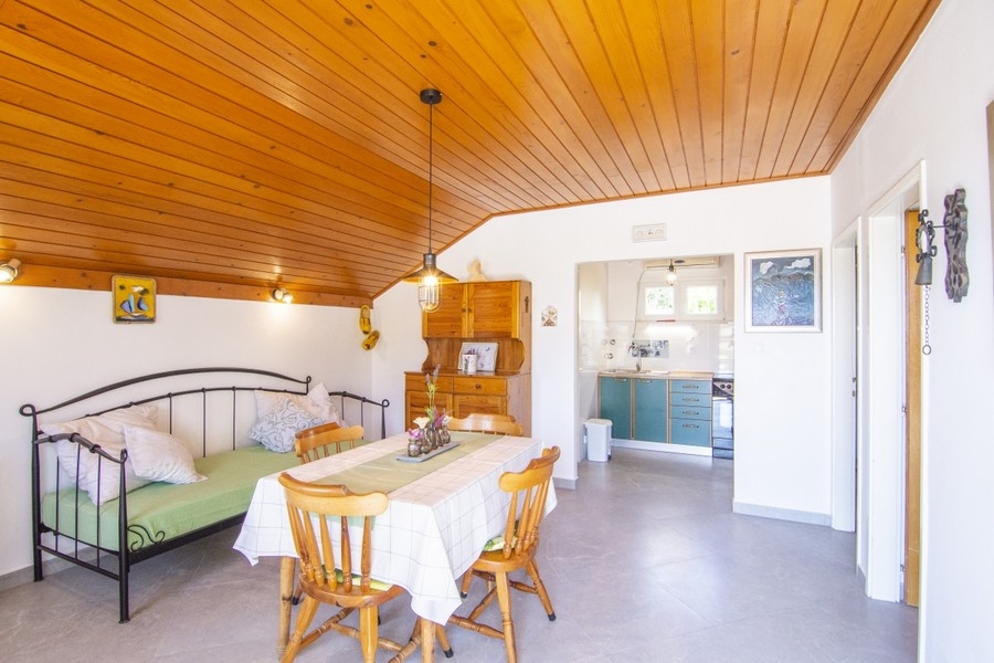 Zona giorno con cucina e soffitto in legno