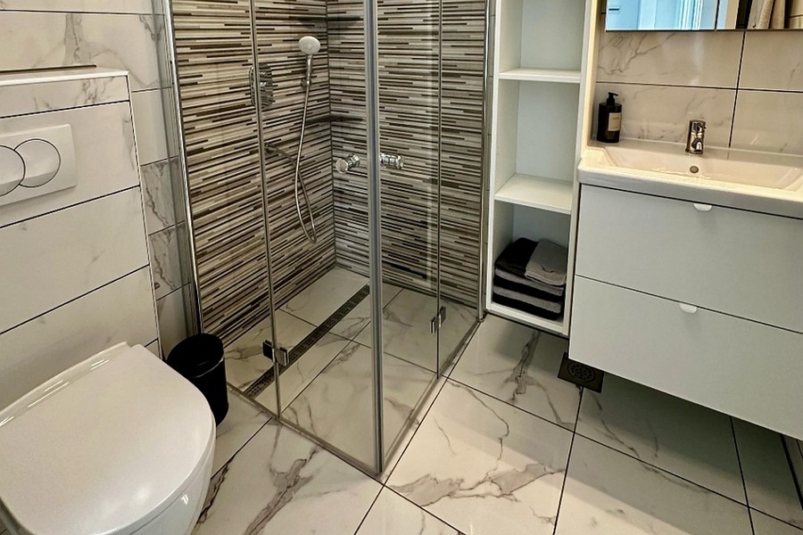 Bagno con moderna doccia in vetro
