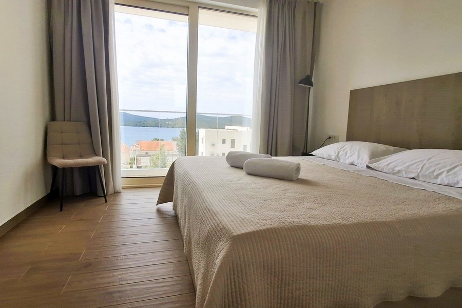 Camera da letto con grande finestra e vista sul mare
