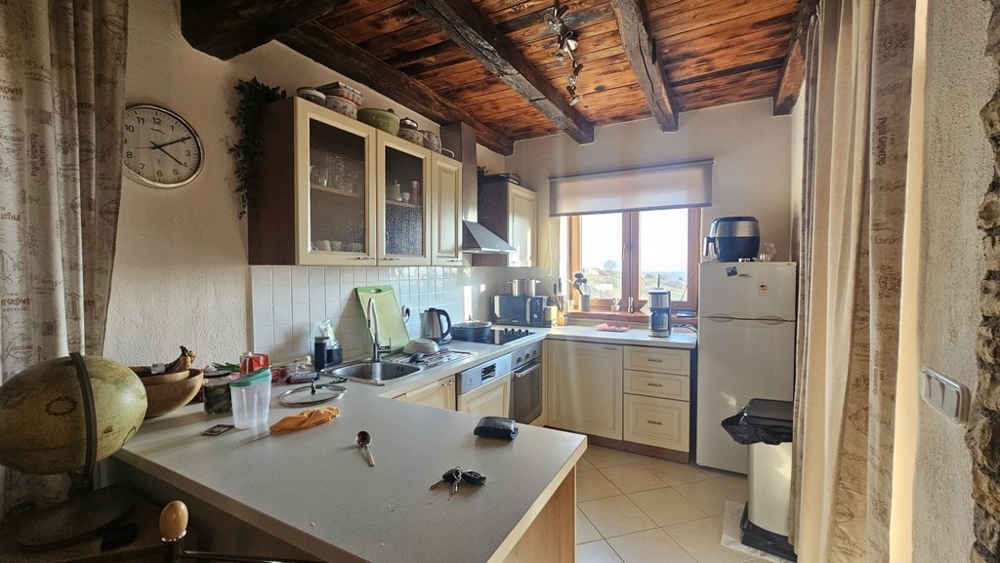 Cucina in stile mediterraneo con soffitto con travi in legno