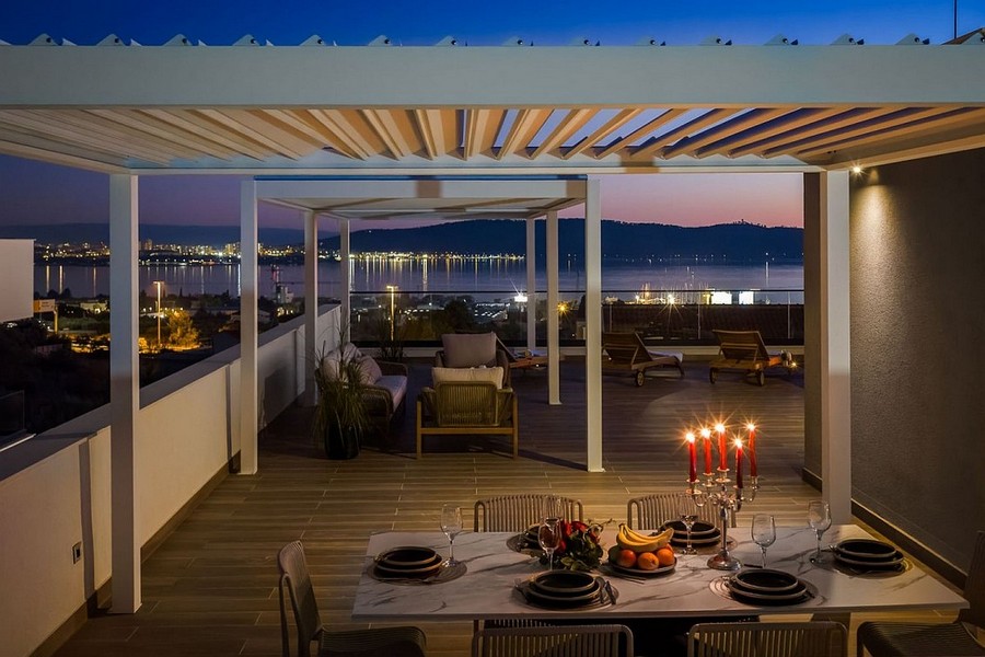 Terrazza sul tetto coperta con tavolo da pranzo di sera