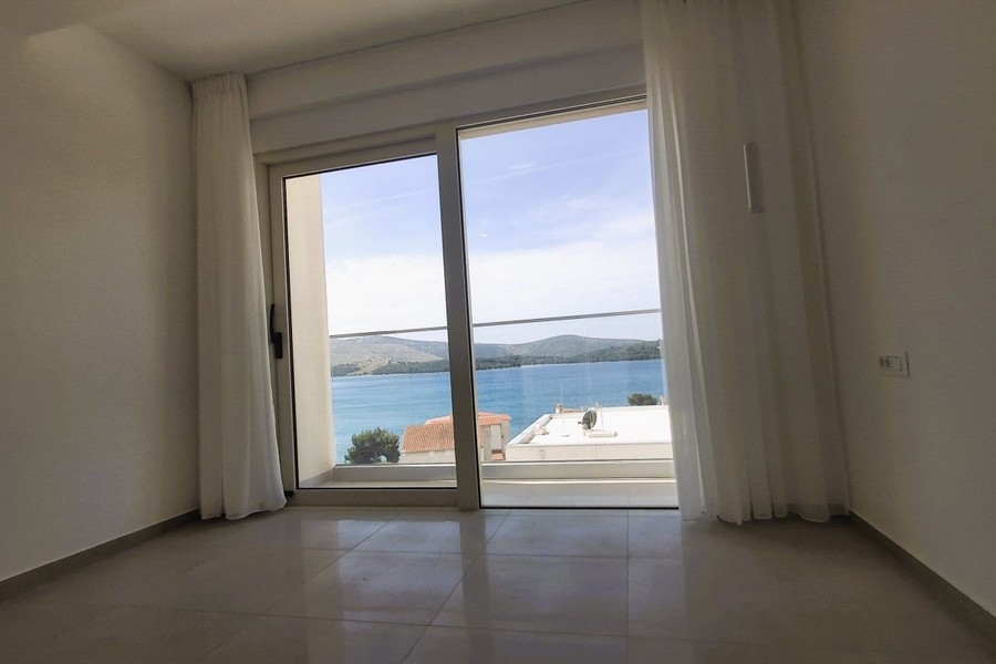 Stanza vuota con porta scorrevole e vista sulla baia e sulle colline