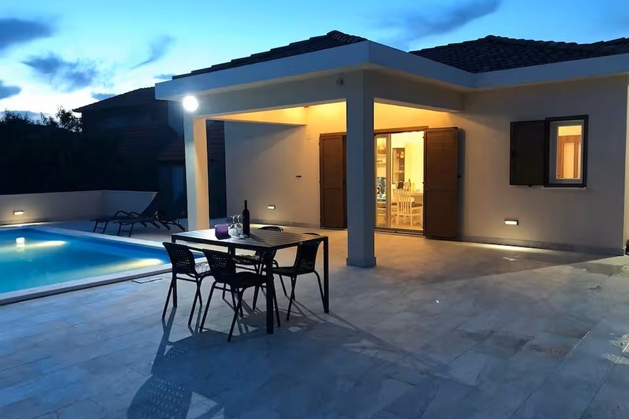 Bungalow di sera con piscina e terrazza coperta