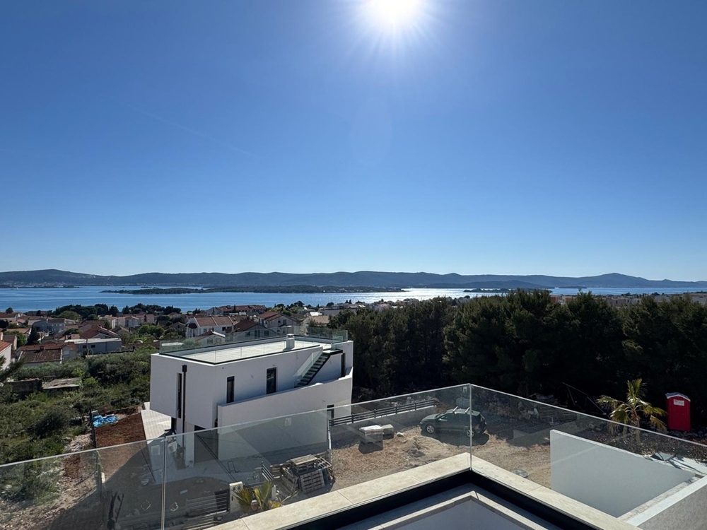 Vista laterale della villa moderna con palma e giardino