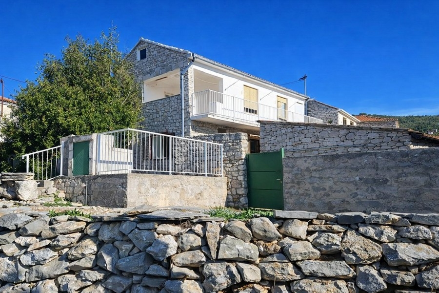 Vista esterna della casa in pietra con muro in pietra