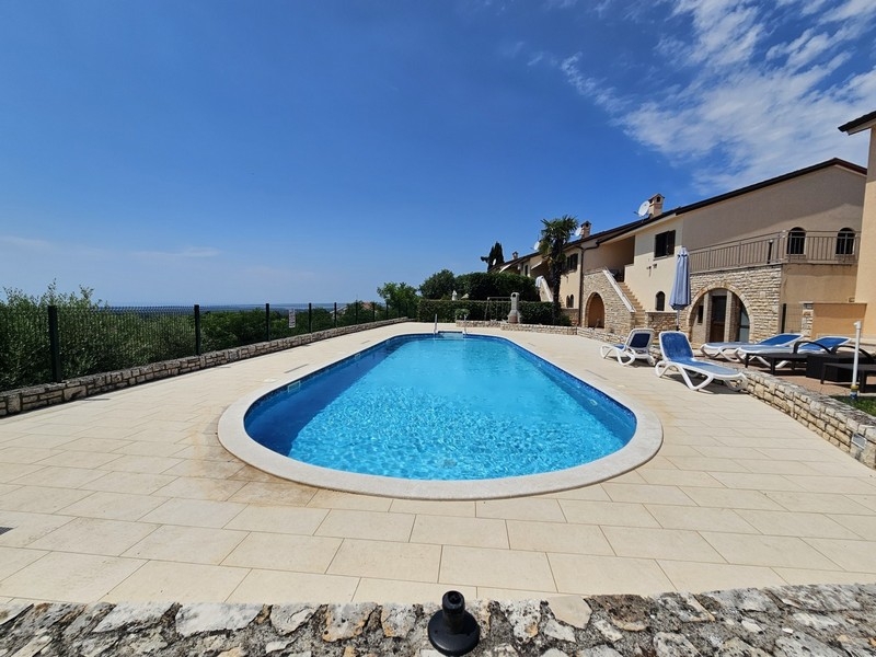 Zona piscina piastrellata con terrazza e complesso residenziale