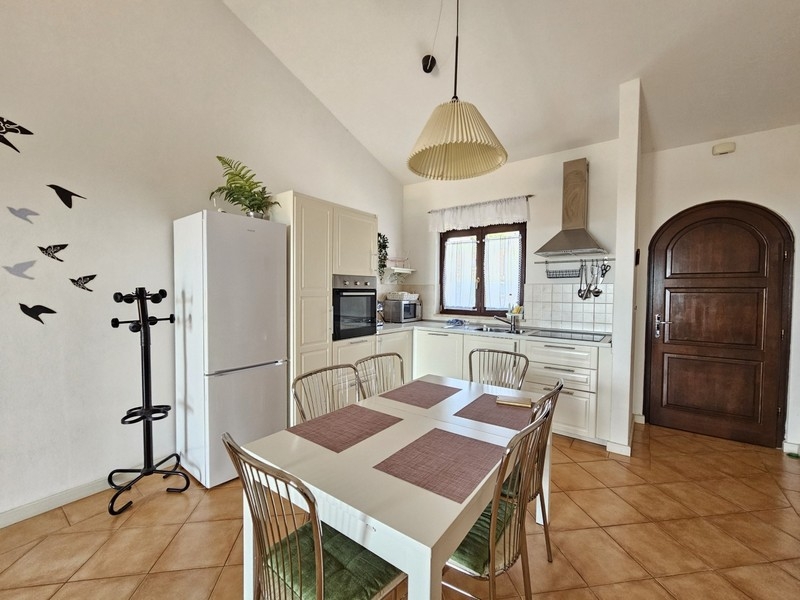 Cucina con zona pranzo e porta in legno massello