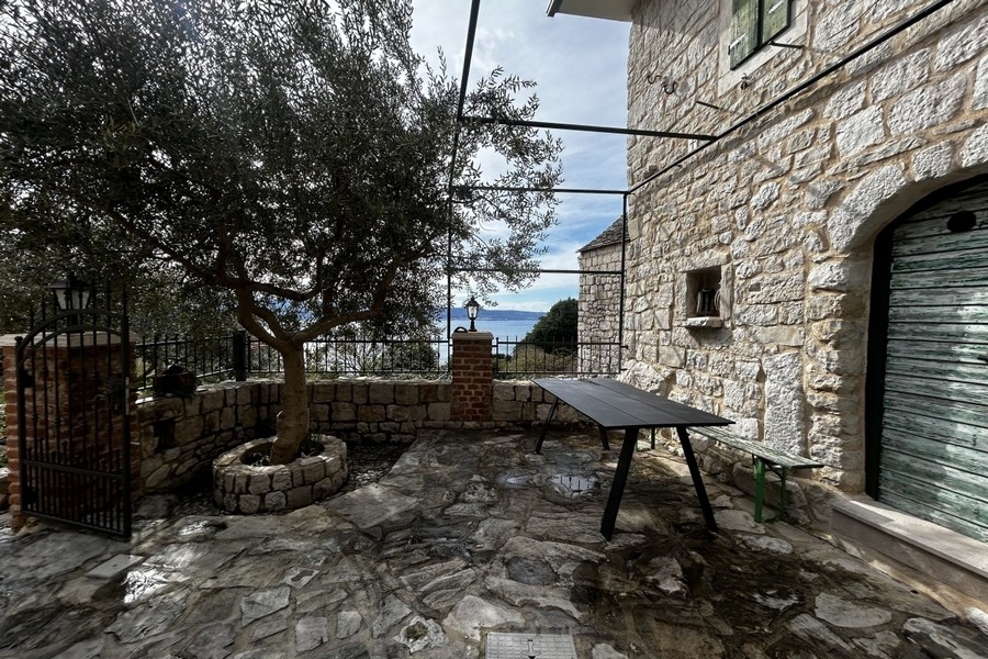 Cortile interno con fontana in pietra e vista mare