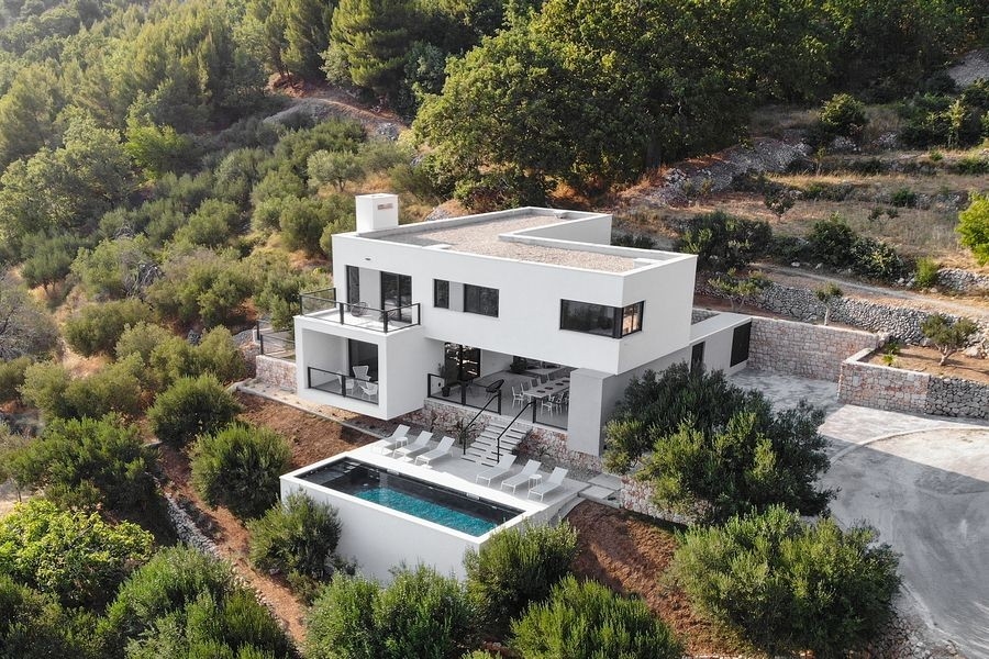 Veduta aerea di una villa moderna con piscina su pendio