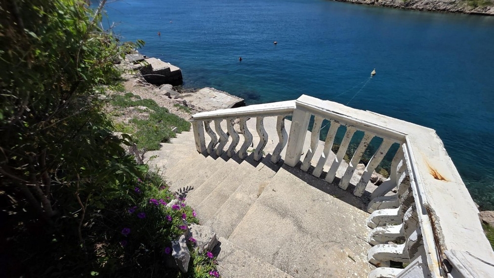 Scala in pietra con balaustra verso il mare