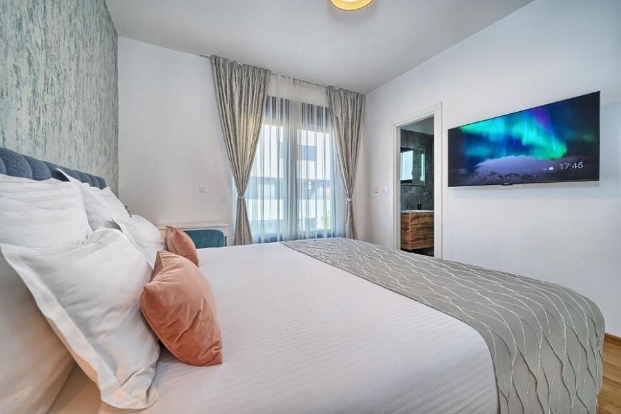 Camera da letto con letto matrimoniale e televisore a parete