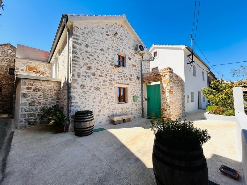 Casa in pietra con porta verde e cortile interno in Croazia